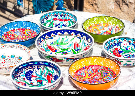 Colorful plates with bright patterns. Plates of orange, green, blue and white. Patterns in the form of different plants. Very beautiful dishes. Stock Photo