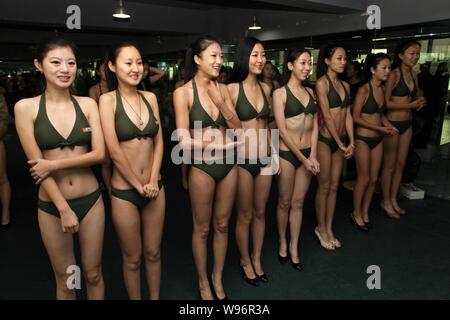 Bikini-dressed female high school students adjust bras during a