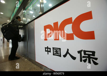 A customer transacts insurance at a branch of PICC (Peoples Insurance Company of China) in Shanghai, China, 22 November 2012.   American International Stock Photo