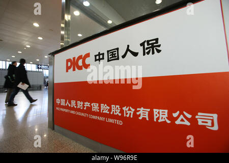 Customers walk past a counter of PICC Property and Casualty Co., Ltd. at a branch in Shanghai, China, 22 November 2012.   American International Group Stock Photo