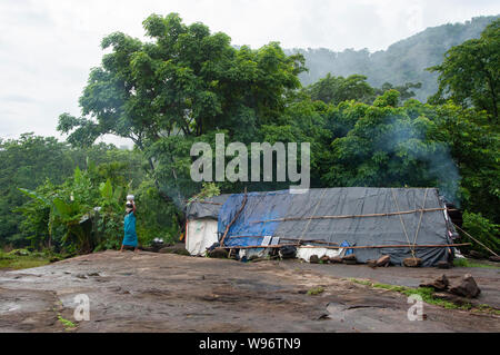 Adivasi Tribal woman belonging to Mudugar tribe outside her home in moist deciduous and evergreen montane rainforest, Kerala, Western Ghats, India Stock Photo