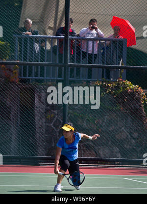 Fans look at Chinese tennis player Zheng Jie while she returns a shot during a training session for Fed Cup in Shenzhen, south Chinas Guangdong provin Stock Photo