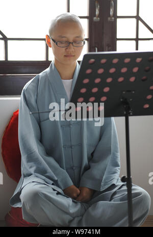 A Chinese Buddhist nun of Guangxuan Art Troupe sits in meditation during a training session at Tiantai Temple on Tiantai Mountain in HongAn county, Hu Stock Photo