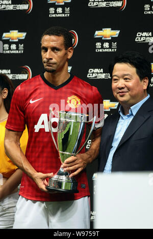 Rio Ferdinand of Manchester United, left, holds a trophy after a friendly soccer match against Shanghai Shenhua during the pre-season tour of Manchest Stock Photo