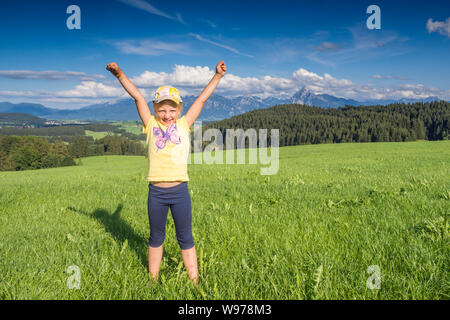 Germany, Bavaria, Allgaeu, happy girl cheering in the fields Stock Photo