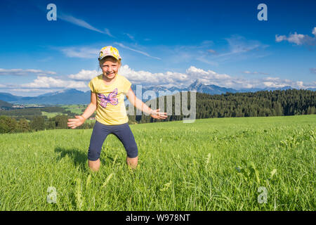 Germany, Bavaria, Allgaeu, happy girl cheering in the fields Stock Photo