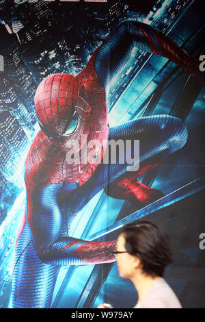 A pedestrian walks past a poster of the movie, The Amazing Spider-man, at a  cinema in Shanghai, China, 28 August 2012. Spider-Man can beat up Batman  Stock Photo - Alamy