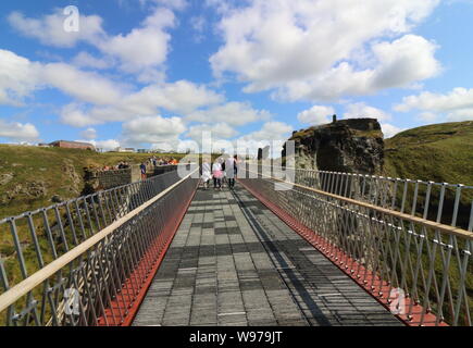 Tintagel, Cornwall, UK. 12th Aug, 2019. People on the controversial new footbridge re-connecting both halves of Tintagel Castle for the first time in 500 years, has at long last been opened. The medieval castle on the Cornwall coast - long rumoured to be the site of King Arthur's legendary Camelot - lost its original bridge sometime between the 15th and 16th centuries. A storm which hit the Cornish coast delayed the bridge's opening. Credit: Keith Mayhew/SOPA Images/ZUMA Wire/Alamy Live News Stock Photo