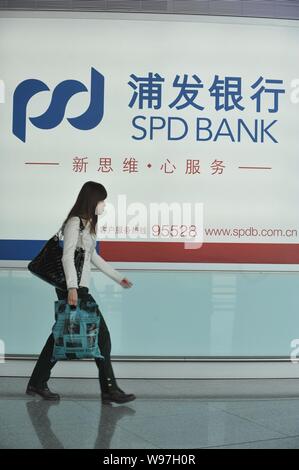 --File--A pedestrian walks past an advertisement for Shanghai Pudong Development Bank in Beijing, China, 28 October 2011.    Chinas securities regulat Stock Photo