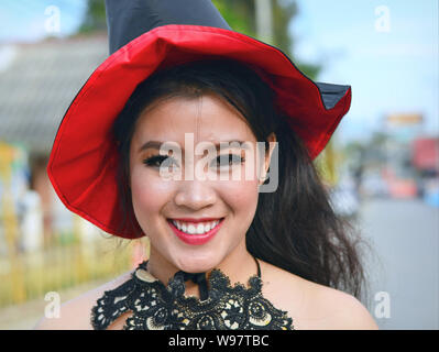 Costumed pretty Thai girl takes part in the village's historical Lanna street parade and smiles for the camera. Stock Photo