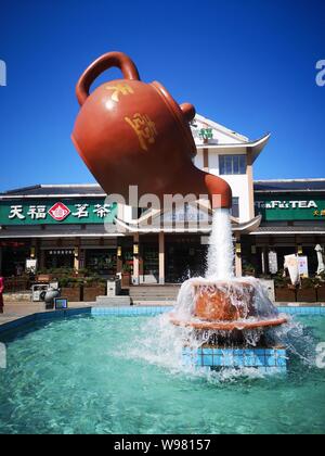 Guizhou, Guizhou, China. 13th Aug, 2019. Guizhou, CHINA-A giant teapot is seen pouring water over the tianfu expressway service area in Guiding county, Qiannan autonomous prefecture, Guizhou province, Aug. 11, 2019.The giant teapot was about two metres above the water, and the water poured down in a column that looked as if it were hanging in the air.Instead, the suspended teapot is supported by plastic pipes in a water column, which pump water out of the pipes and then release the water to form a circulation. Credit: SIPA Asia/ZUMA Wire/Alamy Live News Stock Photo