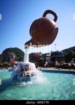 Guizhou, Guizhou, China. 13th Aug, 2019. Guizhou, CHINA-A giant teapot is seen pouring water over the tianfu expressway service area in Guiding county, Qiannan autonomous prefecture, Guizhou province, Aug. 11, 2019.The giant teapot was about two metres above the water, and the water poured down in a column that looked as if it were hanging in the air.Instead, the suspended teapot is supported by plastic pipes in a water column, which pump water out of the pipes and then release the water to form a circulation. Credit: SIPA Asia/ZUMA Wire/Alamy Live News Stock Photo