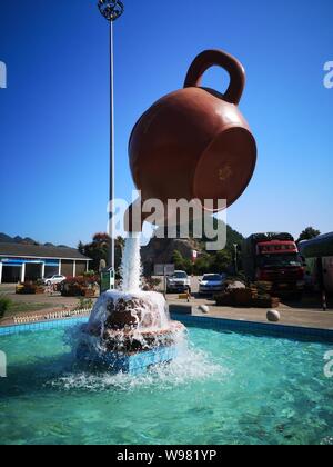 Guizhou, Guizhou, China. 13th Aug, 2019. Guizhou, CHINA-A giant teapot is seen pouring water over the tianfu expressway service area in Guiding county, Qiannan autonomous prefecture, Guizhou province, Aug. 11, 2019.The giant teapot was about two metres above the water, and the water poured down in a column that looked as if it were hanging in the air.Instead, the suspended teapot is supported by plastic pipes in a water column, which pump water out of the pipes and then release the water to form a circulation. Credit: SIPA Asia/ZUMA Wire/Alamy Live News Stock Photo