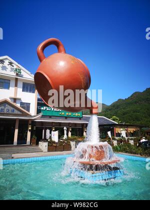 Guizhou, Guizhou, China. 13th Aug, 2019. Guizhou, CHINA-A giant teapot is seen pouring water over the tianfu expressway service area in Guiding county, Qiannan autonomous prefecture, Guizhou province, Aug. 11, 2019.The giant teapot was about two metres above the water, and the water poured down in a column that looked as if it were hanging in the air.Instead, the suspended teapot is supported by plastic pipes in a water column, which pump water out of the pipes and then release the water to form a circulation. Credit: SIPA Asia/ZUMA Wire/Alamy Live News Stock Photo