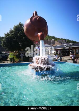 Guizhou, Guizhou, China. 13th Aug, 2019. Guizhou, CHINA-A giant teapot is seen pouring water over the tianfu expressway service area in Guiding county, Qiannan autonomous prefecture, Guizhou province, Aug. 11, 2019.The giant teapot was about two metres above the water, and the water poured down in a column that looked as if it were hanging in the air.Instead, the suspended teapot is supported by plastic pipes in a water column, which pump water out of the pipes and then release the water to form a circulation. Credit: SIPA Asia/ZUMA Wire/Alamy Live News Stock Photo