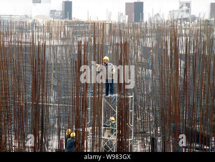 Chinese workers labour at a construction site of a residential project in Nanjing city, east Chinas Jiangsu Province, February 22, 2011.   China will Stock Photo