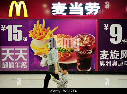 --FILE--Local residents walk past advertisements for McDonalds in Changzhou city, east Chinas Jiangsu province, 2 October 2011.   McDonalds Corp., the Stock Photo