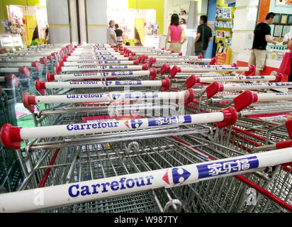 --FILE--Chinese customers walk past rows of shopping carts at a Carrefour supermarket in Nanjing city, east Chinas Jiangsu province, 31 July 2010.   C Stock Photo