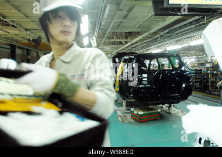 Chinese factory workers assemble a Toyota car on the assembly line at ...
