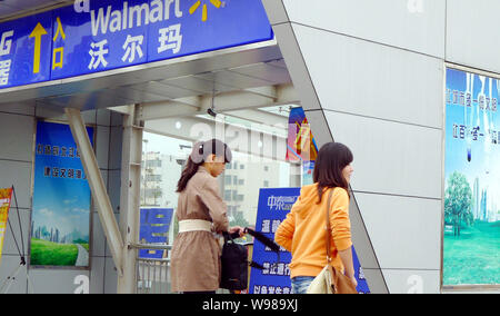 --FILE--Local residents walk past a Walmart Supercenter in Chongqing, China, 29 September 2011.   The government of southwest Chinas Chongqing Municip Stock Photo