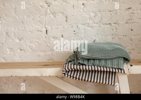 Folded blankets on wooden bench Stock Photo