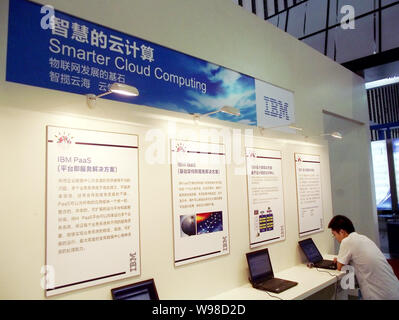 --FILE--A Chinese man uses a laptop computer in front of introductions of IBMs cloud computing services during a software expo in Nanjing city, east C Stock Photo