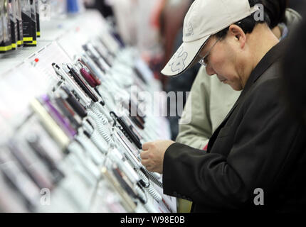 --FILE--Shoppers try out mobile phones at a Media Markt store in Shanghai, China, 18 November 2010.   China is on the verge of becoming the first coun Stock Photo