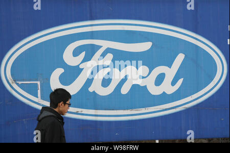 --File--A pedestrian walks past a logo of Ford in Qingdao, east Chinas Shandong province, 11 December 2011.   Following its recent engine and gearbox Stock Photo