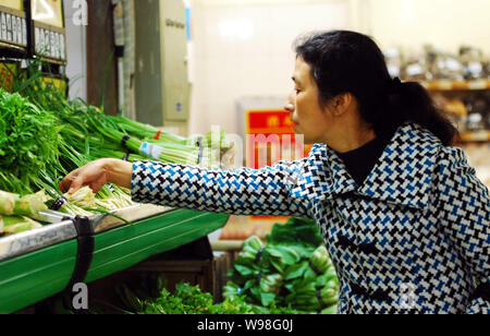 --FILE--A Chinese shopper buys vegetables at a supermarket in Jiujiang city, east Chinas Jiangxi province, 11 March 2011.   China may not be able to m Stock Photo