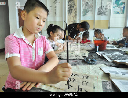 Students learn calligraphy in a class in Zhouping, east Chinas Shandong province, 29 August 2011.   Calligraphy, traditional way of recording, is grad Stock Photo