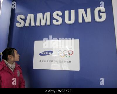 --File--A pedestrian walks past a logo of Samsung in Nantong, east Chinas Jiangsu province, 23 December 2011.   Sony Corp has agreed to sell its nearl Stock Photo