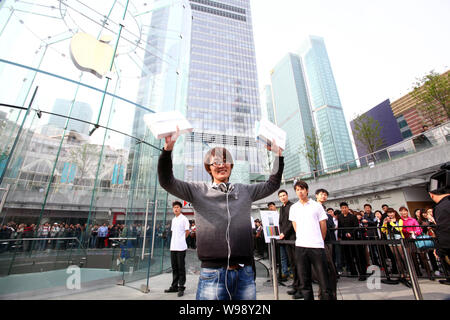 The first buyer of the iPad 2 at an Apple Store celebrates outside the store in the Lujiazui Financial District in Pudong, Shanghai, China, 6 May 2011 Stock Photo