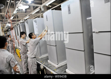--FILE--Chinese factory workers manufacture refrigerators in the plant of Haier in Qingdao city, east Chinas Shandong province, 19 August 2010.   Chin