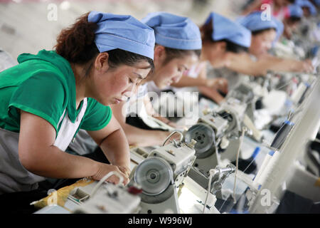 --FILE--Female Chinese workers sew clothes to be exported to southeast Asian countries at the garment factory of Huaibei Qiuyan Industrial And Trading Stock Photo