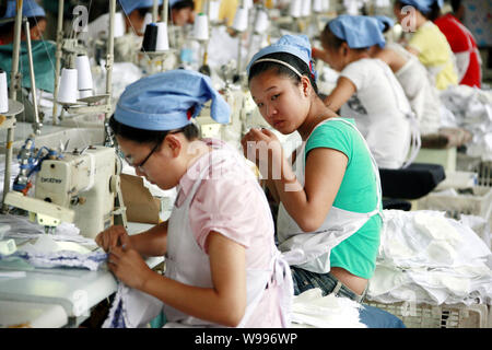 --FILE--Female Chinese workers sew clothes to be exported to southeast Asian countries at the garment factory of Huaibei Qiuyan Industrial And Trading Stock Photo