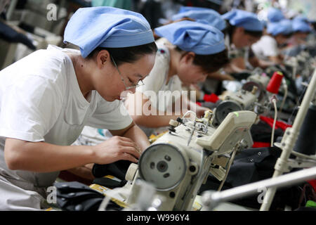 --FILE--Female Chinese workers sew clothes to be exported to southeast Asian countries at the garment factory of Huaibei Qiuyan Industrial And Trading Stock Photo