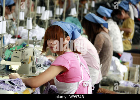 --FILE--Female Chinese workers sew clothes to be exported to southeast Asian countries at the garment factory of Huaibei Qiuyan Industrial And Trading Stock Photo