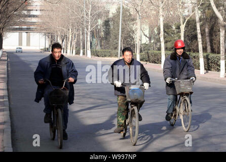 Chinese factory workers ride their bicycles in the steel plant of Shougang Group in Shijingshan, Beijing, China, 13 January 2011.   Shougang Group, a Stock Photo