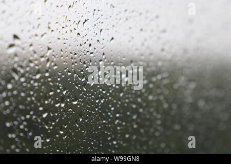 Raindrops on the window glass, selective focus. Beautiful water drops, background for rainy weather Stock Photo