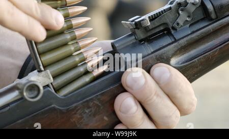 Male hunter in ready to hunt. The man is on the hunt, sport. Hunter man. Hunting period. Male with a gun, rifle. Man is charging a hunting rifle Stock Photo