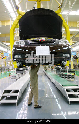 A Chinese factory worker assembles a car on the assembly line at an ...