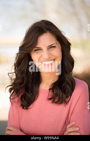 Beautiful mature middle age woman smiling outside. Stock Photo