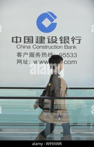 --File--A pedestrian walks past an advertisement for China Construction Bank (CCB) in Beijing, China, 28 October 2011.   Baosteel Group Corporation, t Stock Photo