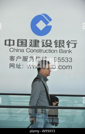 --File--A pedestrian walks past an advertisement for China Construction Bank (CCB) in Beijing, China, 28 October 2011.   Baosteel Group Corporation, t Stock Photo