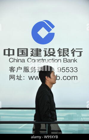 --File--A pedestrian walks past an advertisement for China Construction Bank (CCB) in Beijing, China, 28 October 2011.   Baosteel Group Corporation, t Stock Photo