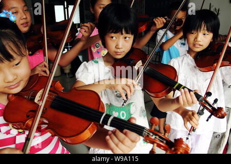 Chinese kids learn playing violin in Donggaocun town, Pinggu District, Beijing, China, 12 August 2010.   Statistics shows that one third of worlds vio Stock Photo