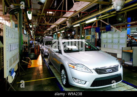 Chinese factory workers assemble Ford Focus cars on the assembly line ...