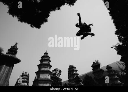 A young Shaolin monk practises kungfu at the Shaolin Temple in Dengfeng city, central Chinas Henan province, 15 August 2009. Stock Photo