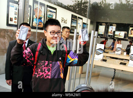 A buyer shows his iPhone 4 smartphones at the Apple Store in the Joy City shopping mall in the Xidan commercial district in Beijing, China, 25 Septemb Stock Photo