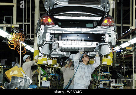 Chinese factory workers assemble a Toyota car on the assembly line at ...